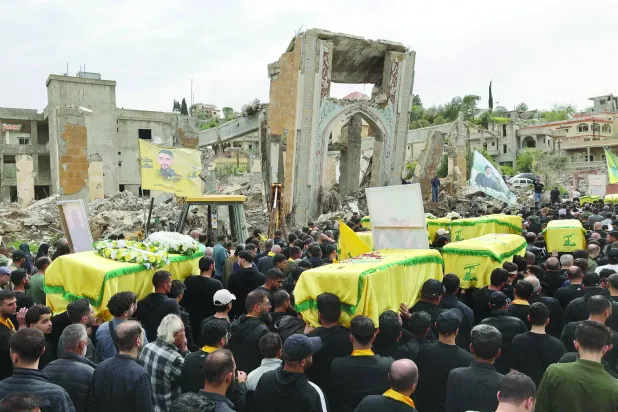 
مناصرون لـ«حزب الله» يشاركون في تشييع مقاتلين في بلدة الطيبة جنوب لبنان 6 أبريل (أ.ف.ب)