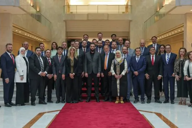 الرئيس السوري أحمد الشرع في صورة تذكارية مع وفد من الجالية السورية بالولايات المتحدة الأميركية (الرئاسة السورية)