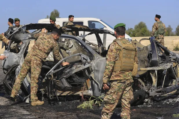 جنود من الجيش اللبناني أمام سيارة تفحمت بسبب غارة إسرائيلية في جنوب لبنان (أ.ب)