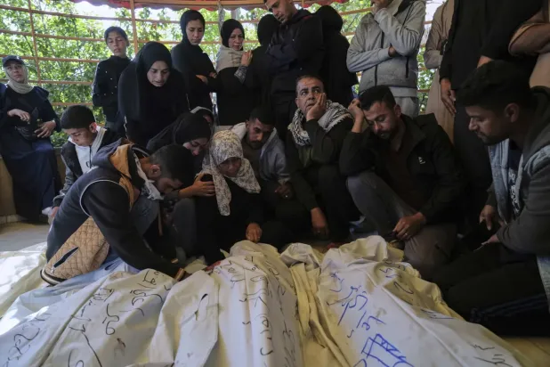 Gazze'nin güneyinde İsrail saldırısında öldürülen yakınlarının cenazeleri başında ağlayan Filistinliler (AP)