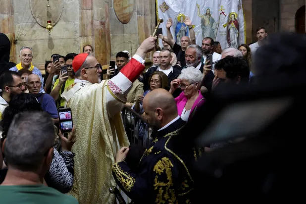 بطريرك القدس بييرباتيستا بيتسابالا يقود قداس عيد الفصح في كنيسة القيامة بالبلدة القديمة الأحد (رويترز)