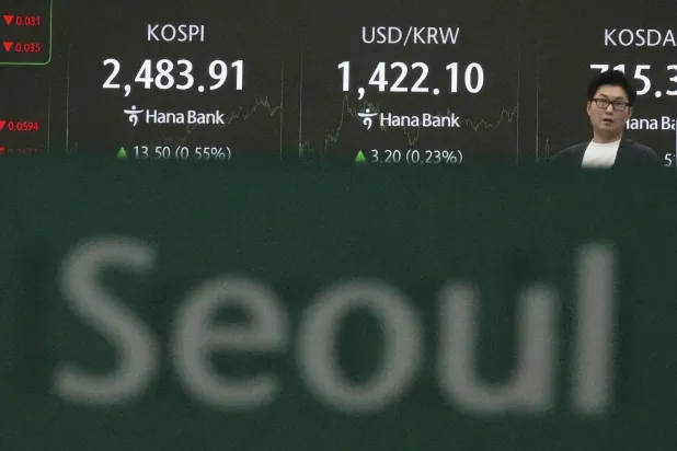 شاشات تعرض مؤشر «كوسبي» وسعر صرف الدولار مقابل الوون في بنك هانا بسيول (أ.ب)