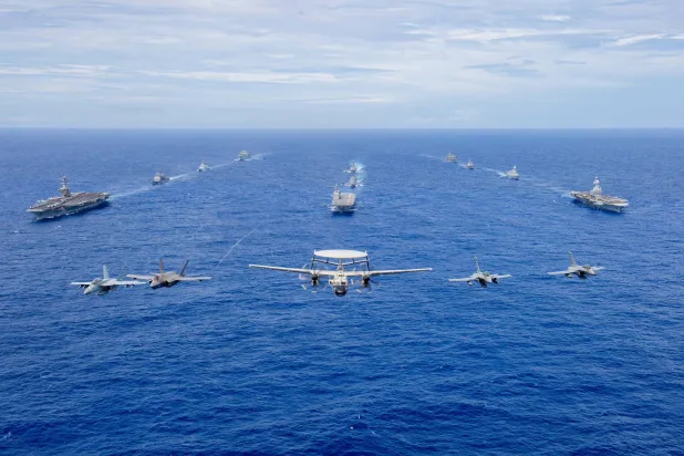 حاملة الطائرات «كارل فينسون» ومجموعتها القتالية وأمامها طائرات (إف 15) و(إف 35) وطائرة إنذار مبكر (صفحة حاملة الطائرات فينسون عبر فيسبوك)