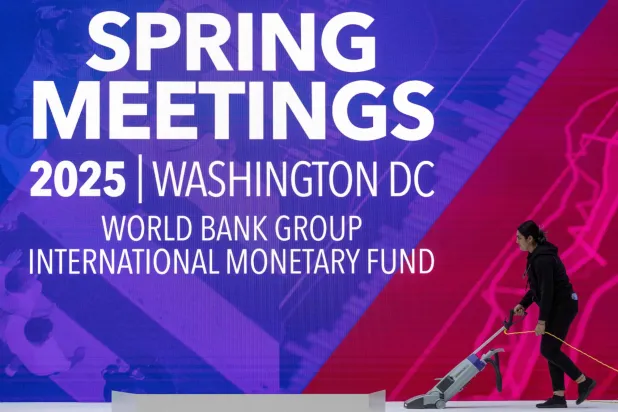 عاملة تنظف المسرح قبيل افتتاح اجتماعات الربيع لـ«صندوق النقد» و«البنك» الدوليين في واشنطن يوم 17 أبريل 2025 (أ.ف.ب)