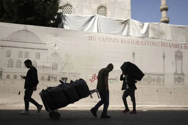 تركيان ينقلان بضائع بمنطقة أمينونو في إسطنبول (أ.ب)