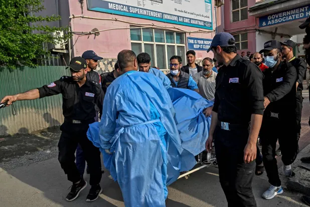 شرطيون ومسعفون ينقلون جريحاً إلى المستشفى في باهالغام (أ.ف.ب)