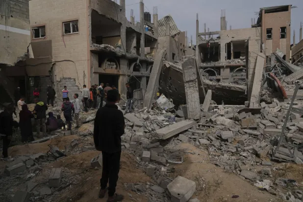 فلسطينيون يتفقدون الدمار الذي خلَّفته ضربة إسرائيلية في خان يونس بقطاع غزة يوم الثلاثاء (أ.ب)