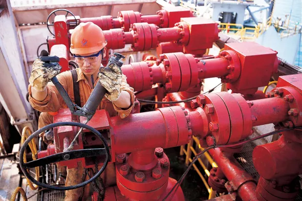 عامل يقوم بصيانة المرافق على منصة حفر نفطية تابعة لشركة الصين الوطنية للنفط البحري (رويترز)