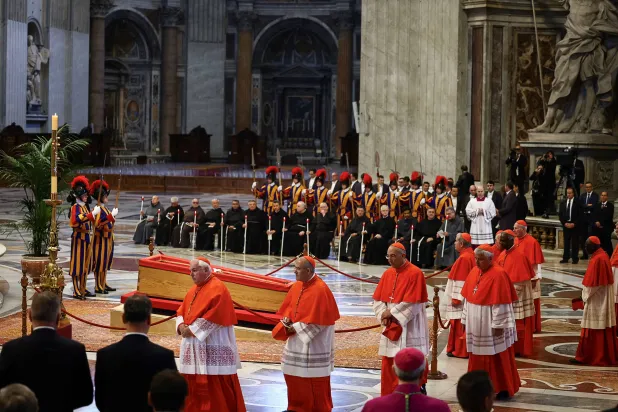 الكرادلة يقدمون التحية بجانب النعش الذي يحتضن جثمان البابا فرنسيس في كاتدرائية القديس بطرس (رويترز)