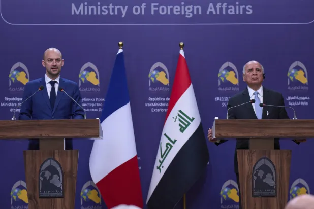 مؤتمر صحافي بين فؤاد حسين وزير الخارجية العراقي مع نظيره الفرنسي جان نويل بارو (أ.ب)