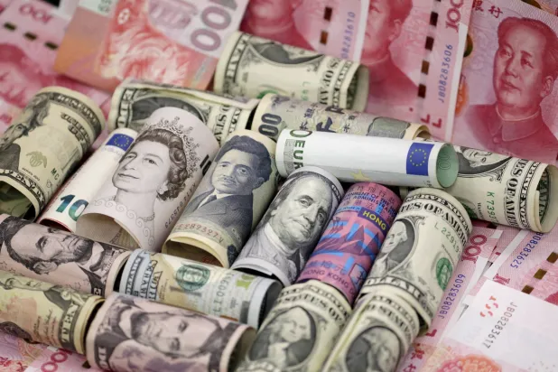 أوراق نقدية من الدولار الأميركي واليوان الصيني والجنيه الإسترليني واليورو والين الياباني (رويترز)