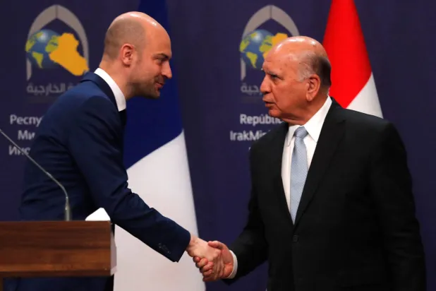 ژان-نوئل بارو و فؤاد حسین پس از نشست خبری مشترک در بغداد با یکدیگر دست دادند(أ.ف.ب)