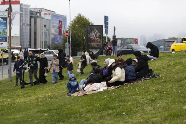 أشخاص مع أمتعتهم يجلسون في حديقة بعد زلزال قوي ضرب إسطنبول (إ.ب.أ)