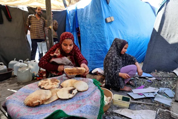 أصبح الطحين عملة نادرة تتشارك عائلات غزة الكميات القليلة منه (أ.ف.ب)