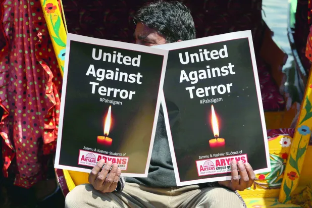 راكب قارب كشميري يحمل لافتتين تنددان بالهجوم المميت على السياح في الجزء الخاضع لإدارة الهند من كشمير خلال احتجاج في سريناغار يوم 24 أبريل 2025 (إ.ب.أ)