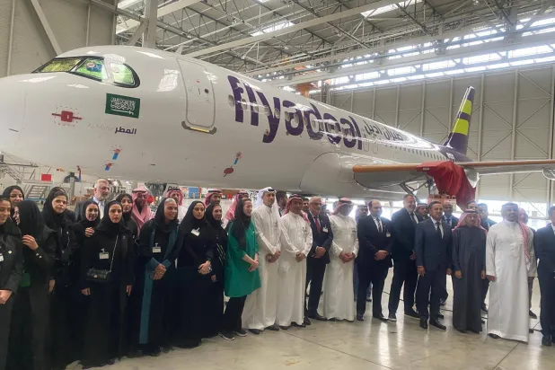 الوفد السعودي في صورة جماعية أمام الطائرة السعودية الجديدة (الشرق الأوسط)