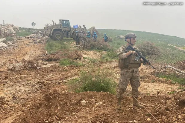 جندي في الجيش اللبناني يواكب جرافة للجيش تعمل على فتح الطرقات بجنوب لبنان (مديرية التوجيه)
