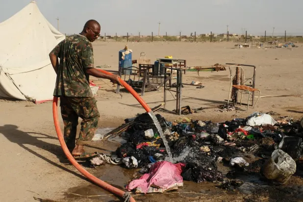 Sudan'ın kuzeyindeki ed-Damir kentinde bir insansız hava aracı saldırısının ardından çıkan yangını söndüren Sudan askeri, 25 Nisan (Reuters)