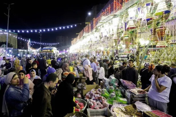 شباب يعملون في إحدى الأسواق بوسط القاهرة قبل شهر رمضان (رويترز)