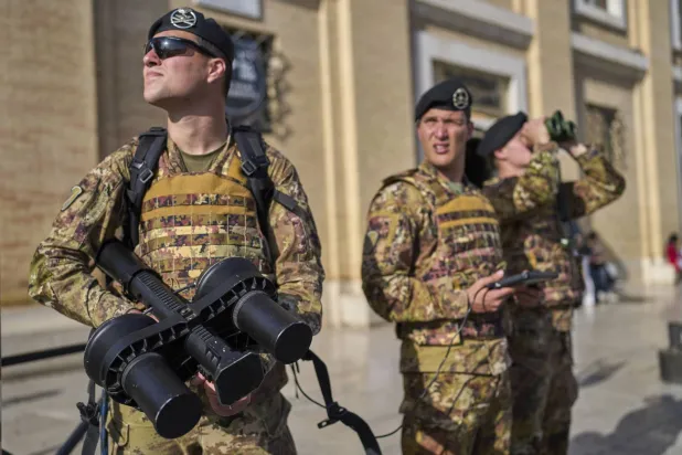 جنود من الجيش الإيطالي يحملون مدفعاً مضاداً للطائرات من دون طيار يقومون بدورية في المنطقة أمام ساحة القديس بطرس (أ.ب)