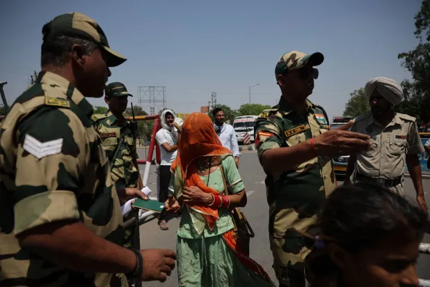 جندي من قوة أمن الحدود يفحص جوازات سفر مواطنين باكستانيين استعداداً لمغادرة الهند بعد أن ألغت الهند تأشيراتهم الممنوحة عند معبر أتاري - واجاه الحدودي قرب أمريتسار بالهند في 27 أبريل 2025 (رويترز)
