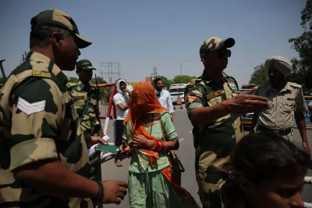  Sınır Güvenlik Gücü askeri, 27 Nisan 2025'te Hindistan'ın Amritsar yakınlarındaki Attari-Wagah sınır kapısında vizelerini iptal etmesinin ardından Hindistan'dan ayrılmaya hazırlanan Pakistanlıların pasaportlarını kontrol ediyor. (Reuters)