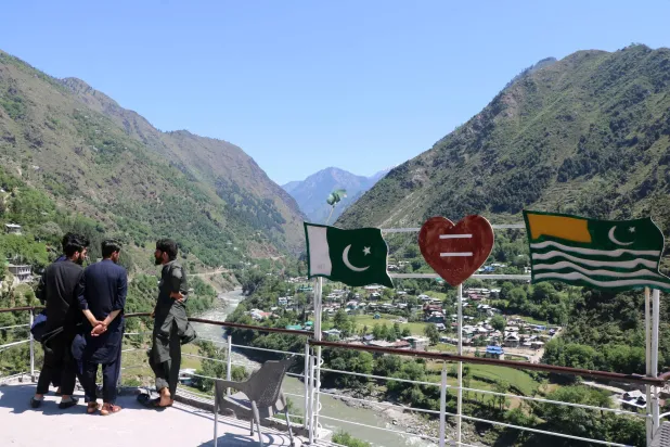 سيَّاح في الشطر الذي تديره باكستان من كشمير يطلون على الشطر الذي تديره الهند منها (إ.ب.أ)