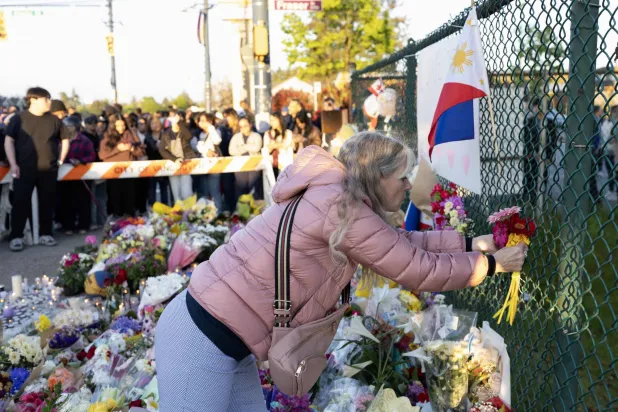 وقفة احتجاجية بالشموع بالقرب من موقع حادثة دهس سيارة حشداً خلال مهرجان «لابو لابو» في فانكوفر بكندا أسفرت عن مقتل 11 شخصاً على الأقل وإصابة آخرين يوم الأحد (أ.ف.ب)