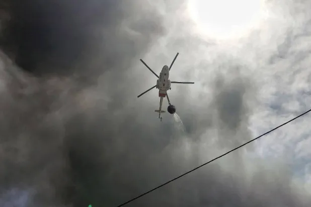 مروحية إيرانية تساعد في مكافحة الحريق الذي شبّ بميناء «رجائي» بإيران (إ.ب.أ)