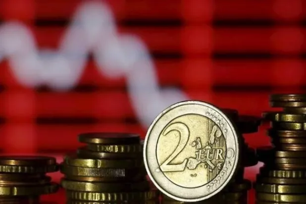 عملات اليورو أمام مخطط الأسهم في هذه الصورة التوضيحية (رويترز)