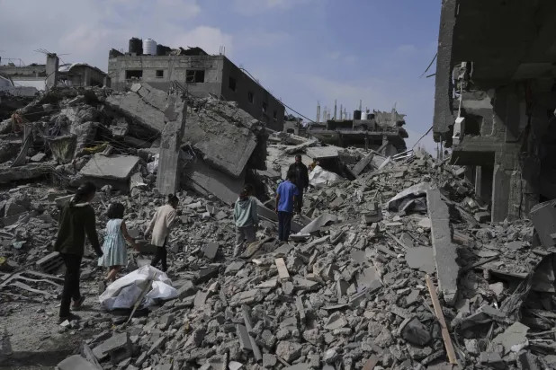 فلسطينيون يسيرون بين الأنقاض بعد غارة جوية إسرائيلية على بيت لاهيا شمال قطاع غزة 28 أبريل 2025 (أ.ب)