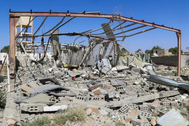 رجل يمشي وسط مركز إيواء الأفارقة في صعدة (رويترز)