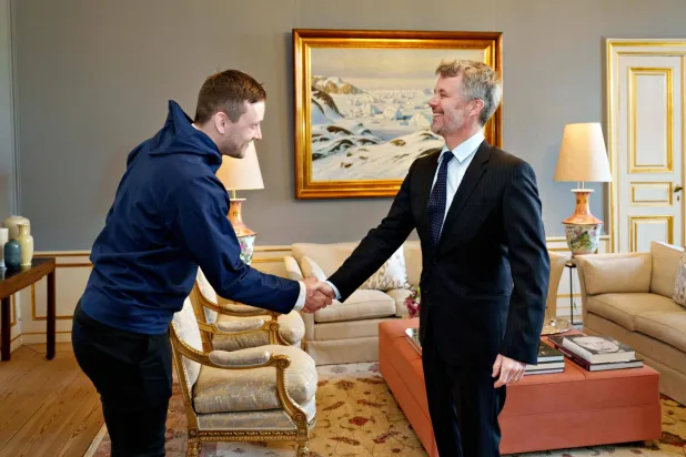 رئيس وزراء غرينلاند ينس فريدريك نيلسن في استقبال ملك الدنمارك فريدريك (أ.ف.ب)