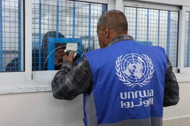 موظف يوزع الأدوية في عيادة تديرها «الأونروا» بمخيم الشاطئ للاجئين غرب مدينة غزة (أ.ف.ب)