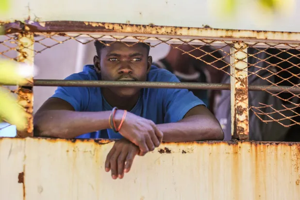 رجل هايتي محتجز داخل سيارة دورية الهجرة أمام مستشفى في سانتو دومينغو بجمهورية الدومينكان 21 أبريل 2025 (أ.ف.ب)