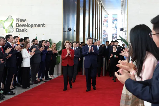 الرئيس الصيني شي جينبينغ وديلما روسيف رئيسة بنك التنمية الجديد لدى زيارة الأول لمقر البنك في مدينة شنغهاي الثلاثاء (رويترز)