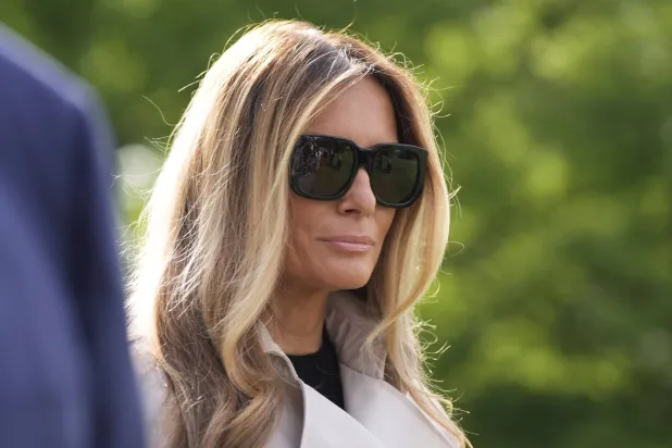 السيدة الأميركية الأولى ميلانيا ترمب تستمع إلى الرئيس دونالد ترمب وهو يتحدث مع الصحافيين أثناء مغادرتها مع الرئيس على متن طائرة مارين وان من الحديقة الجنوبية للبيت الأبيض يوم الجمعة الماضي (أ.ب)