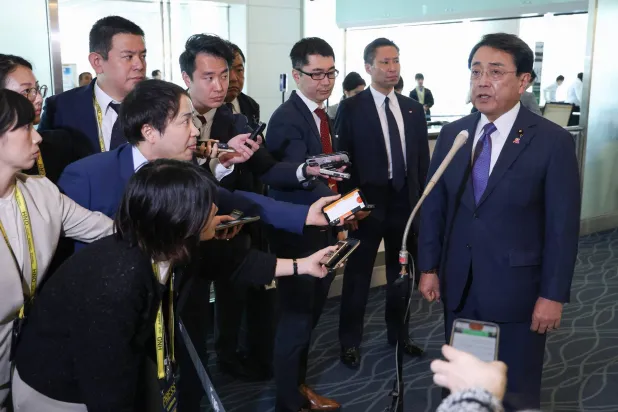 وزير الاقتصاد الياباني ريوسي أكازاوا يتحدث مع الصحافيين قبل مغادرة العاصمة طوكيو متجهاً إلى واشنطن (أ.ف.ب)