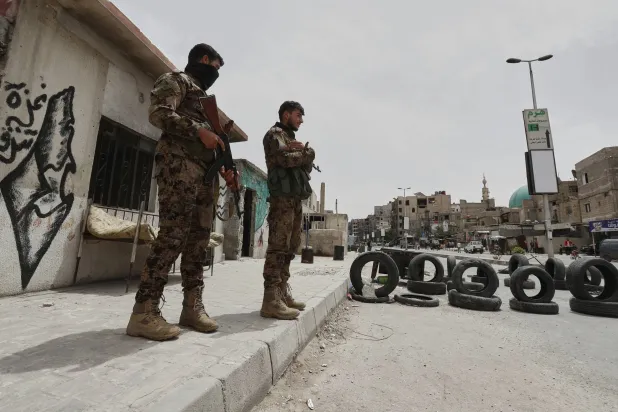 قوات الأمن السورية تقف حراسة على نقطة تفتيش عند أحد مداخل ضاحية جرمانا بعد اشتباكات الثلاثاء (أ.ب)