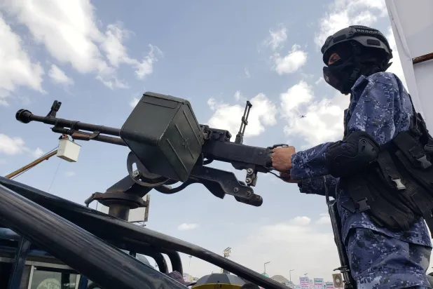 مقاتل حوثي يمسك ببندقية آلية مثبتة على سيارة خلال احتجاجات ضد القصف الأميركي في صنعاء (إ.ب.أ)