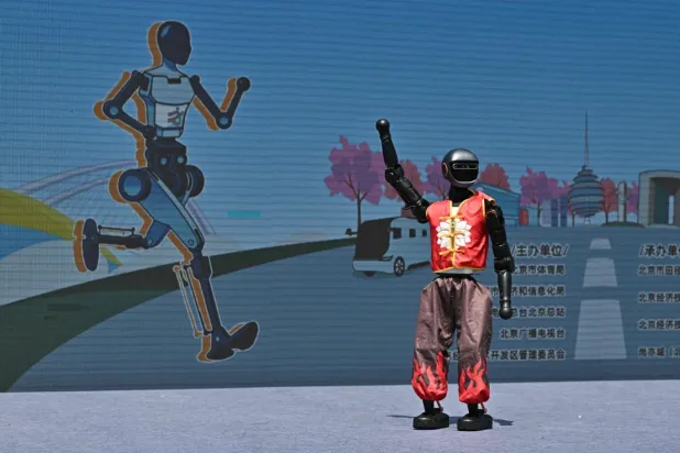 Yarış sırasında insanlar su içerken robotların da bataryaları değiştirildi (AFP)