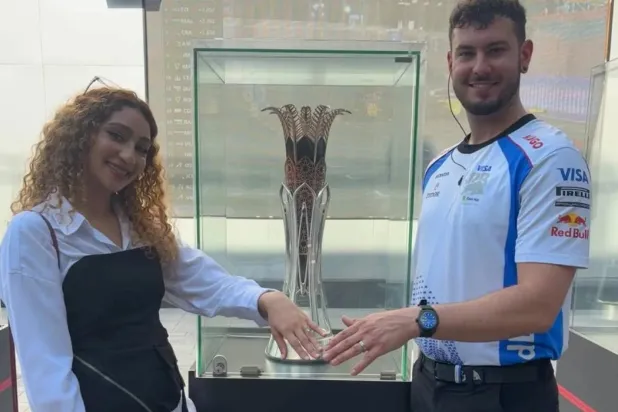 Lamia and Abdulrahman show their rings while standing next to the Saudi Arabian Grand Prix Trophy. Photo: Asharq Al-Awsat 