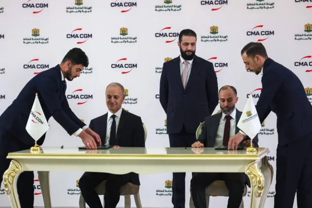تم توقيع العقد بحضور الرئيس الانتقالي أحمد الشرع بين الهيئة العامة للمنافذ البرية والبحرية مع الشركة الفرنسية في قصر الشعب بدمشق (أ.ف.ب)