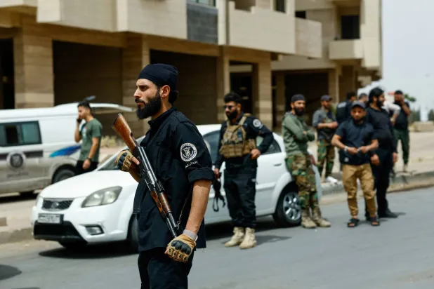 أفراد من قوات الأمن السورية يقفون حراسة عند نقطة تفتيش في أشرفية صحنايا بالقرب من دمشق 1 مايو 2025 (رويترز)