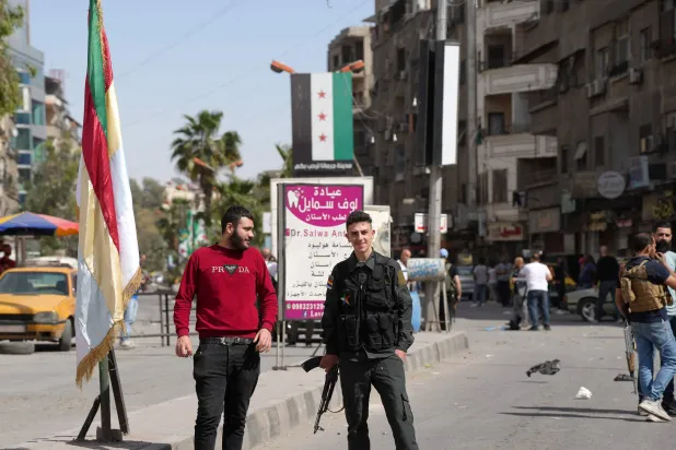 Druze men carry weapons at a checkpoint in Jaramana near Damascus (AFP). 