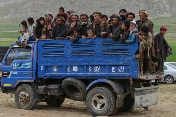 أفغان يركبون شاحنة على طريق في منطقة جورم، بولاية بدخشان، في الأول من مايو 2025 (أ ف ب)