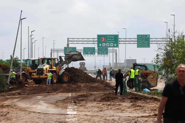 فرق الطوارئ الإسرائيلية تعمل قرب مطار بن غوريون بعد سقوط صاروخ أُطلق من اليمن يوم الأحد (أ.ف.ب)