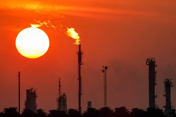غروب الشمس خلف مجمع مصفاة الدورة النفطية في بغداد (أرشيفية - رويترز)