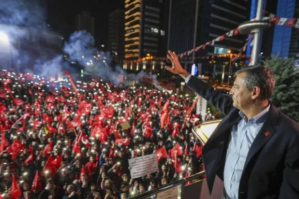 رئيس حزب الشعب الجمهوري أوزغور أوزيل يلوح لأنصار حزبه الذين تجمعوا ليل الأحد أمام مقره للترحيب به بعد تعرضه لاعتداء في إسطنبول (حزب الشعب الجمهوري - إكس)