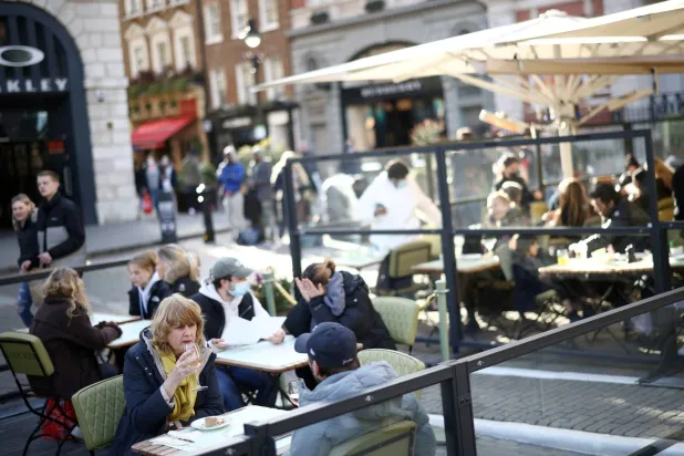 يجلس الناس بمنطقة مطاعم خارجية في كوفنت غاردن بلندن (أرشيفية - رويترز)